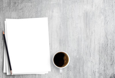 Directly above shot of coffee cup on table against white wall