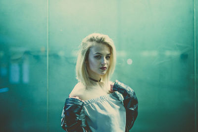 Portrait of young woman against wall