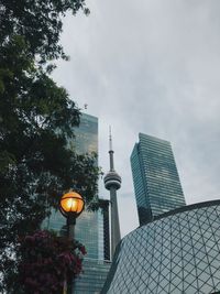 Low angle view of street light by building against sky