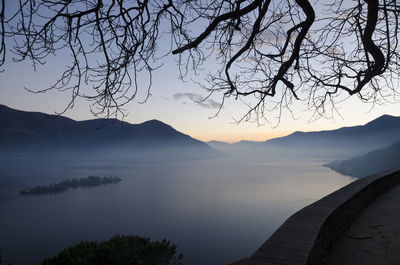 Scenic view of lake and mountains against sky at sunset