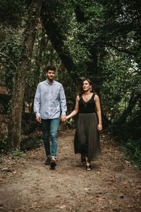 Full length portrait of young couple in forest