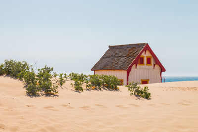 House on beach against clear sky