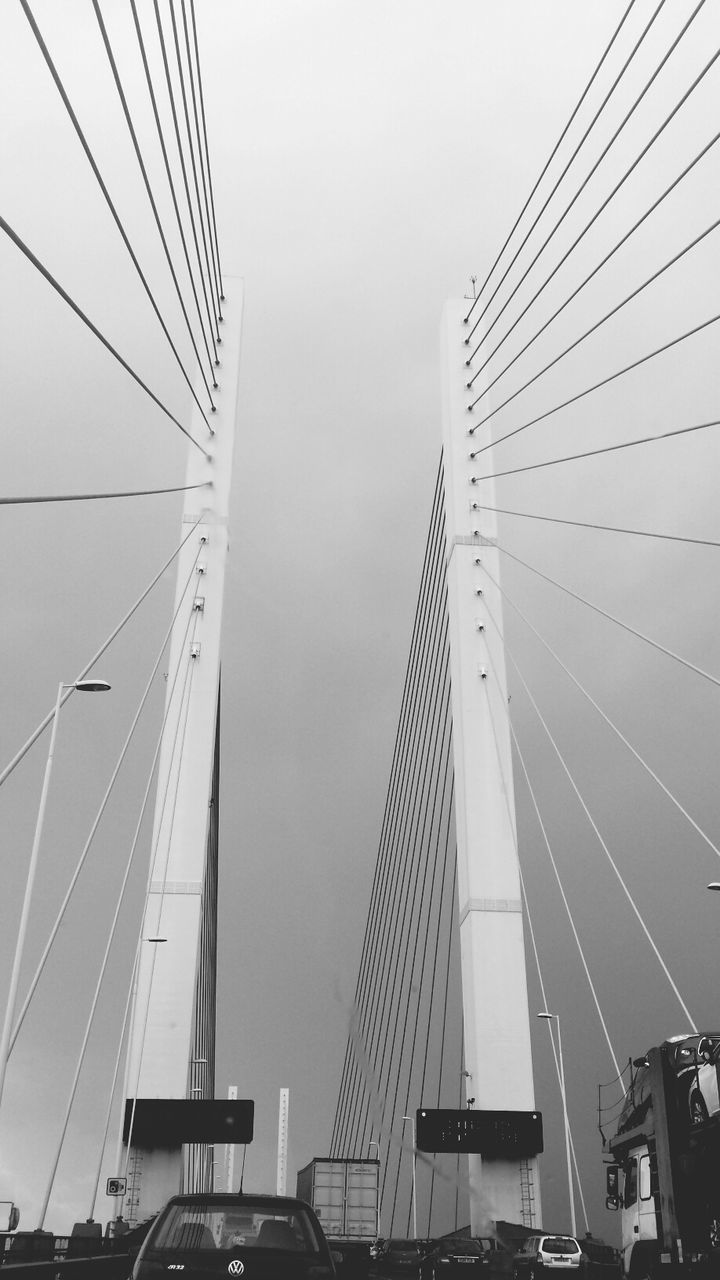 low angle view, transportation, connection, clear sky, sky, cable, built structure, mode of transport, engineering, day, architecture, power line, part of, travel, outdoors, suspension bridge, bridge - man made structure, no people, cable-stayed bridge, steel cable