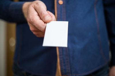 Close-up of man holding paper with text
