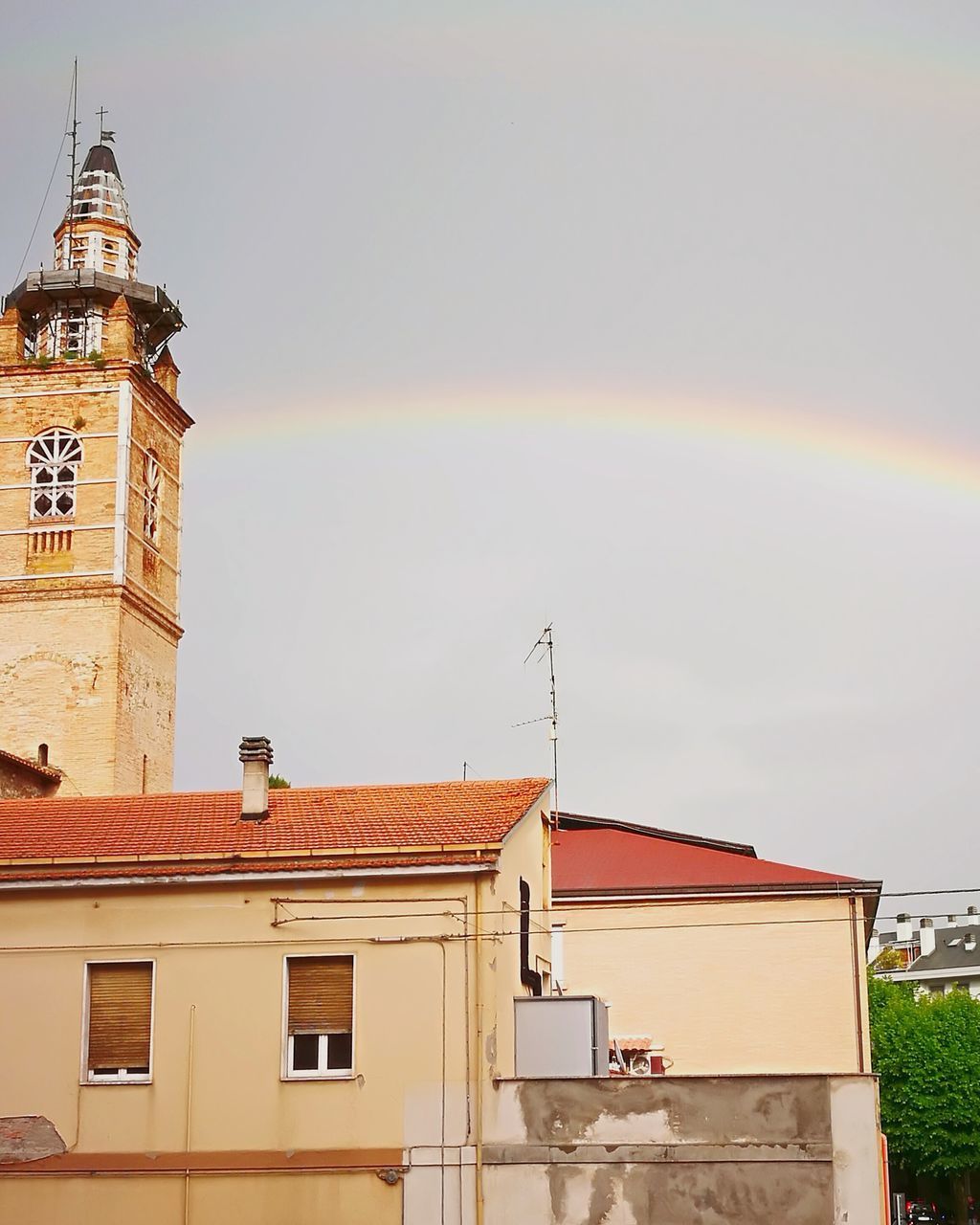 LOW ANGLE VIEW OF RAINBOW OVER BUILDINGS IN CITY