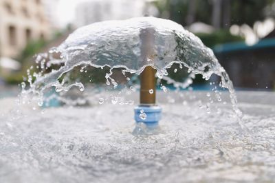 Close-up of water fountain on street in city