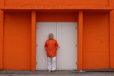 Rear view of woman standing against wall