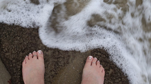 Low section of person standing on beach