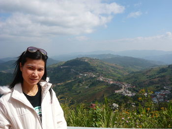 Portrait of woman standing on mountain against sky