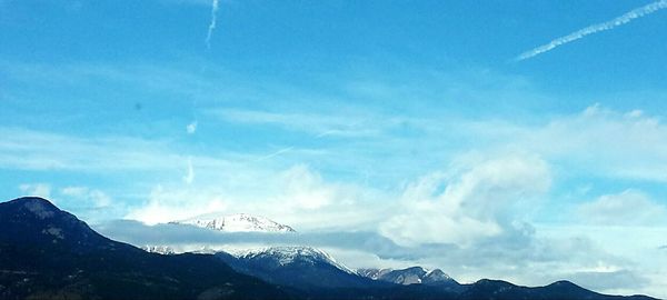 Scenic view of mountains against blue sky