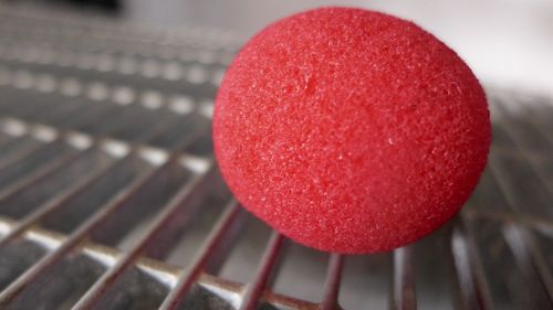 Close-up of red clown on metal grate