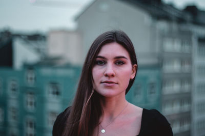 Portrait of beautiful young woman against sky