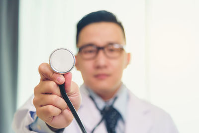 Portrait of man holding eyeglasses