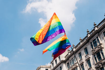 Low angle view of pride flags against buildings