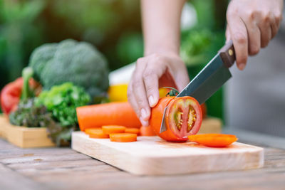 Cropped image of person preparing food on cutting board