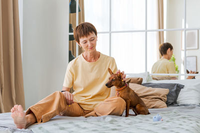 Dog training teams. happy woman training pet at home in living room, playing