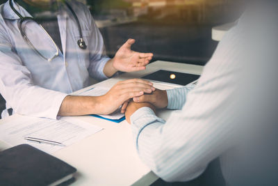 Midsection of couple holding hands on table