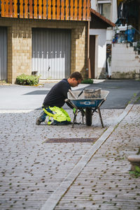 Rear view of man sitting on street