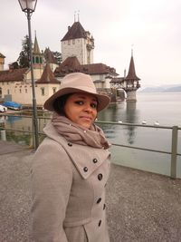 Portrait of woman standing against historic building in lake