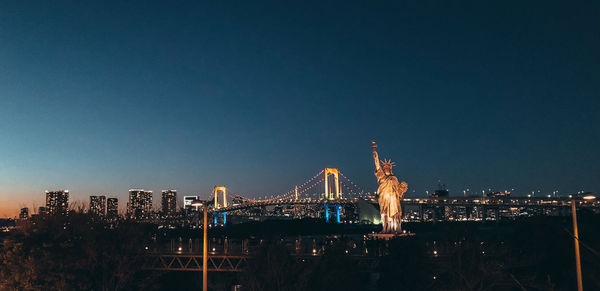 Illuminated city buildings against sky at night