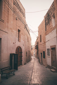 Empty alley amidst buildings in city