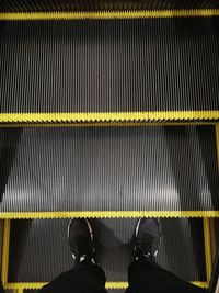 Low section of man standing on escalator