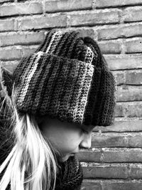 Side view of cute girl wearing warm clothing by wall