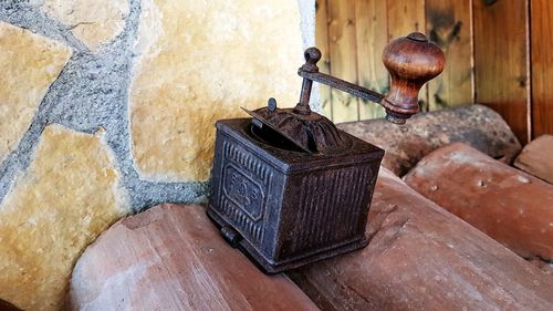 Close-up of old metal on table against wall