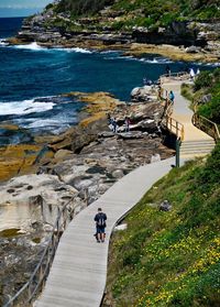 High angle view of people on cliff by sea