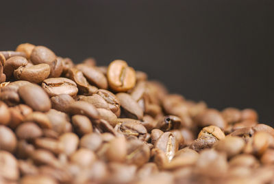 Close-up of coffee beans on table against black background