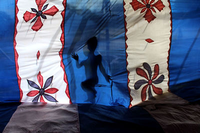 Low section of woman against blue wall