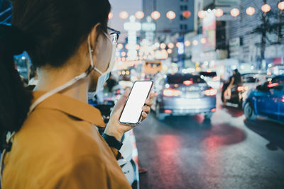 Midsection of woman using smart phone on street