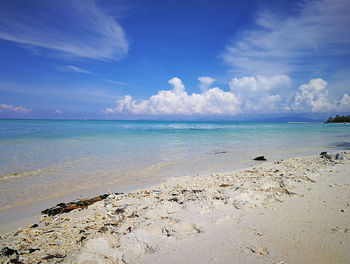 Scenic view of beach against blue sky