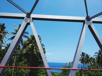 Low angle view of palm trees against clear blue sky