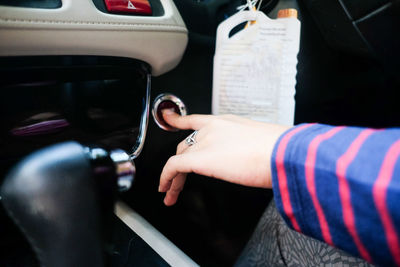 Midsection of woman holding smart phone in car