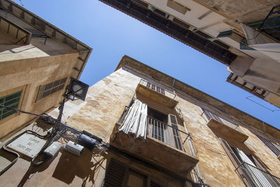 Low angle view of buildings against clear blue sky