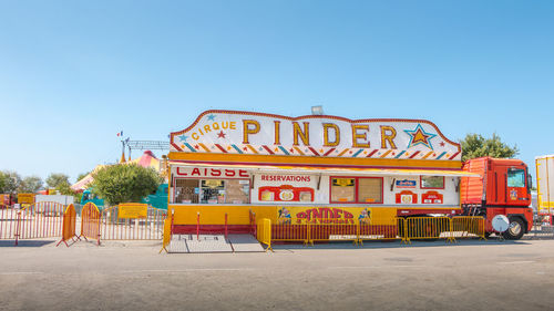 Low angle view of amusement park against clear blue sky