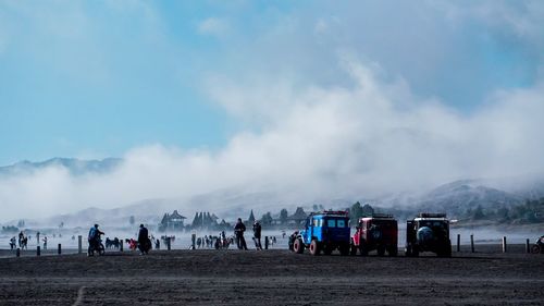 Group of people on mountain road against sky