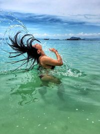 Woman flipping hair in sea