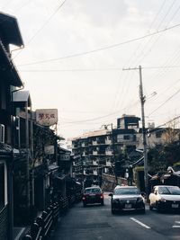 Cars on road in city against sky