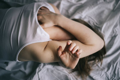 Low section of woman resting on bed