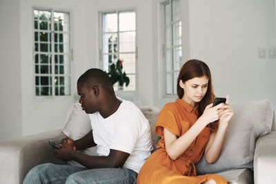 Young couple sitting on sofa at home