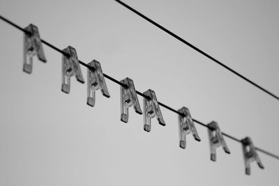 Low angle view of padlocks hanging on metal against sky