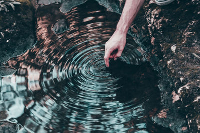 Cropped hand of man standing in water