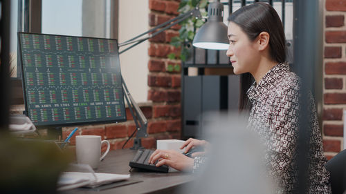 Portrait of young woman using laptop at table