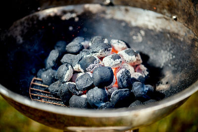 Closeup of glowing coal in metal grill on summer day in the garden