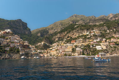 Scenic view of sea by buildings against clear sky