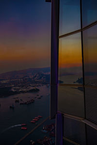 Scenic view of sea by buildings against sky during sunset