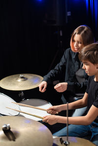 Side view of man playing drum