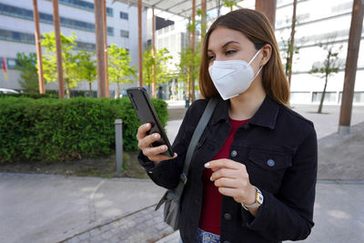 Young woman using mobile phone in city